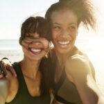 Cropped portrait of two attractive and athletic young women taking selfies while out for a run on the beach
