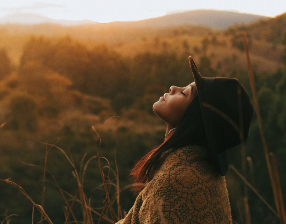 side view of woman looking up in a sunset