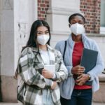 Student couple posing for photo with their masks on
